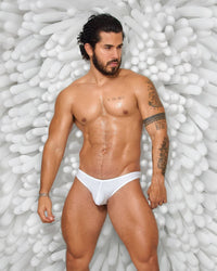 Hombre modelando calzoncillo Power Cup Bikini blanco de lycra y algodón, diseño erótico y sexy con copa realzadora y ajuste cómodo.